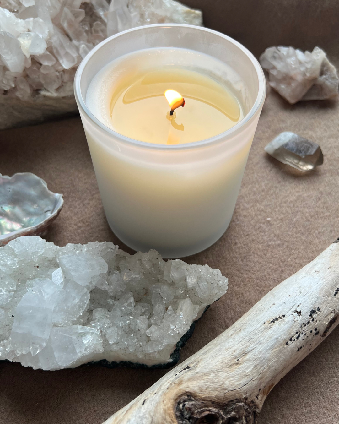 A candle with crystals surrounding it, calming ambiance, peace, serenity. 